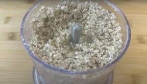 Ground oats in a blender on a wooden table, perfect for homemade baking and gluten-free recipes.